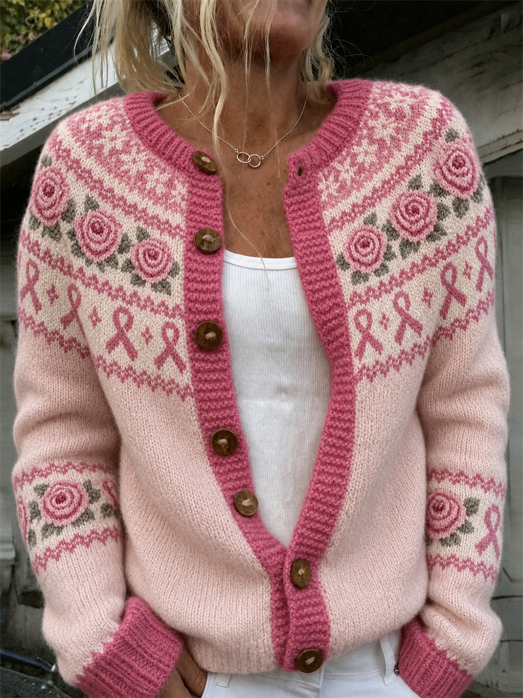 Damjacka i stickat, avslappnad stil, med tryckt mönster med rosa blommor och rosa välgörenhetsband